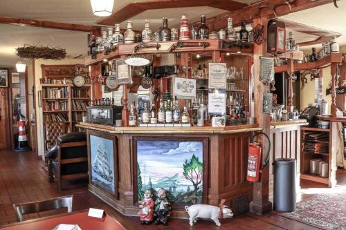 a room with a bar with a tv in it at Gaststaette & Pension Schinkenkrug in Hinrichshagen