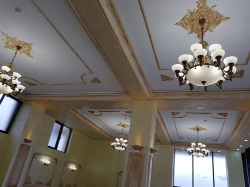 a room with a ceiling with chandeliers at Hotel Ildis in Iaşi