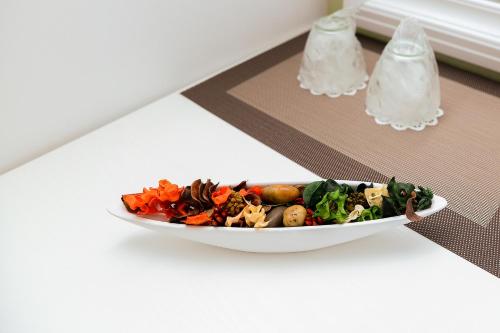 a plate of food on a table with a salad at Hotel Ildis in Iaşi