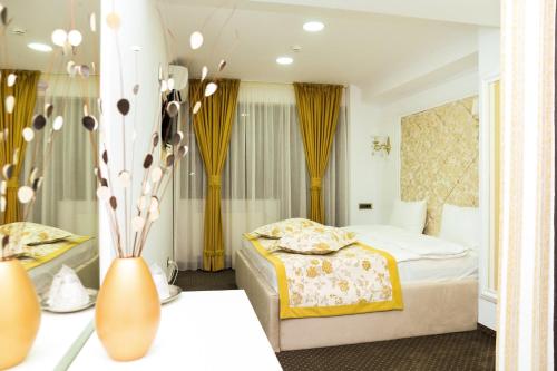 a hotel room with two beds and a vase at Hotel Ildis in Iaşi
