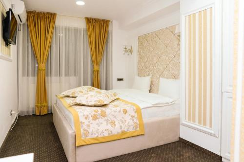 a hotel room with a bed and a window at Hotel Ildis in Iaşi