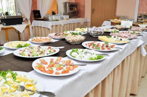 a table with many plates of food on it at Pensjonat Sosnowe Zacisze in Susiec
