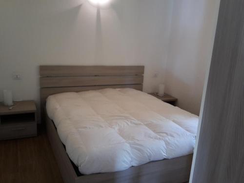 a bedroom with a white bed with two night stands at Villaggio delle Alpi in Pré-Saint-Didier