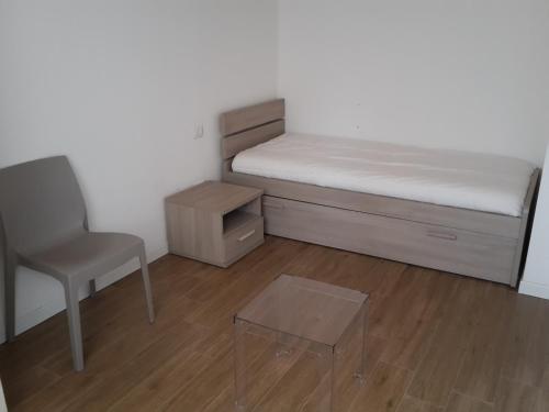 a small bedroom with a bed and a chair at Villaggio delle Alpi in Pré-Saint-Didier