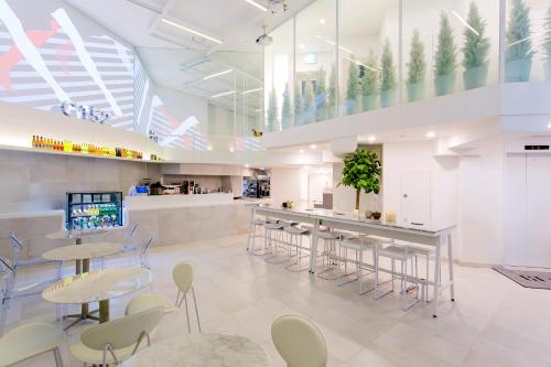 a cafeteria with tables and chairs and a bar at H Avenue Hotel Idae Shinchon in Seoul