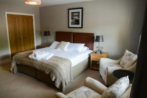 a hotel room with a bed and a chair at The Gower Hotel in Swansea
