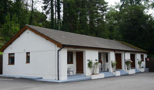 a small white building with chairs in a parking lot at The Gower Hotel in Swansea