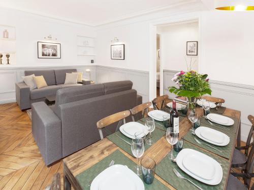 un salon avec une table et un canapé dans l'établissement LivinParis - Luxury 4 Bedrooms Opera Lafayette II, à Paris