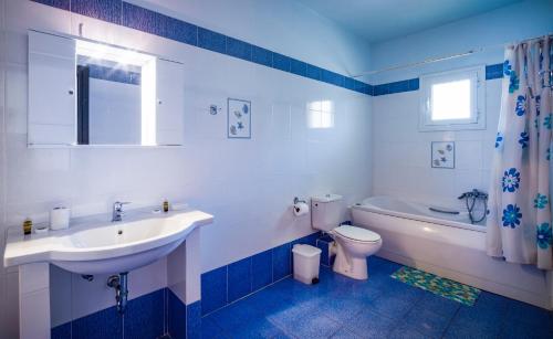 a white bathroom with a sink and a toilet at Limnionas Bay Village Hotel in Marathokampos
