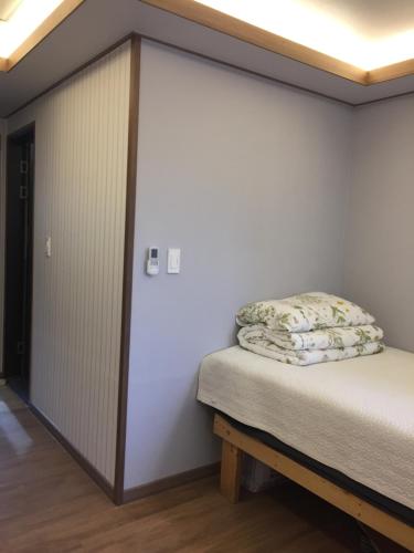 a bed in a room with a large wall at Guest House Dalggume in Mokpo