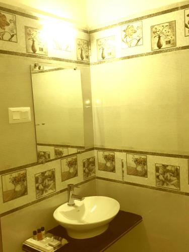 a bathroom with a sink and a mirror at Hotel Abhilasha in Giriak
