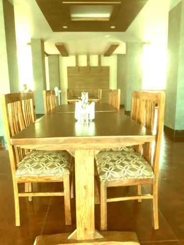 a wooden table with two chairs and a dining room at Hotel Abhilasha in Giriak