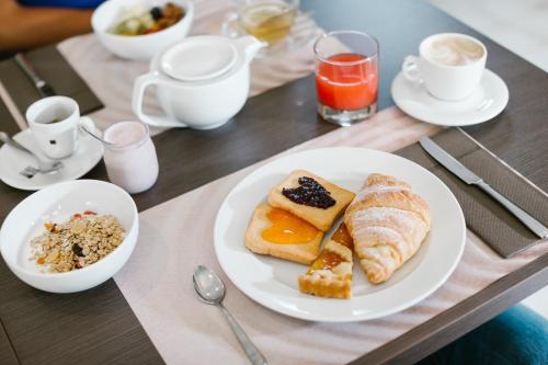 a table with a plate of breakfast foods and coffee at Diamante MHotel in Collegno