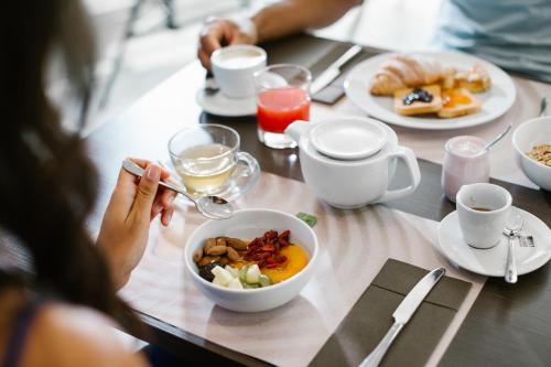 a person sitting at a table with a bowl of food at Diamante MHotel in Collegno