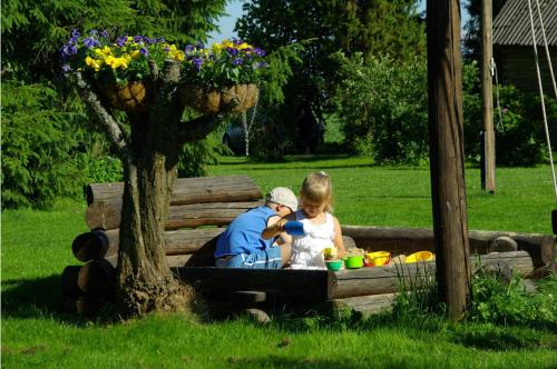 a man and a little girl sitting on a park bench at Vanasauna Guesthouse in Valma