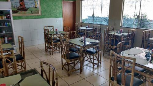 a restaurant with tables and chairs in a room at Hotel Maringa in Maringá