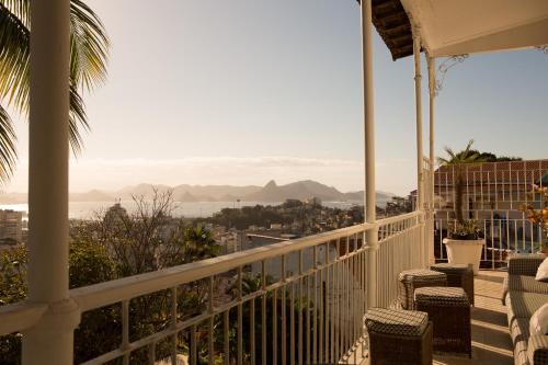 uma varanda com cadeiras e vista para o oceano em Mama Ruisa Boutique Hotel no Rio de Janeiro