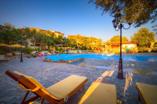 a pool with two lounge chairs and a light pole at Limnionas Bay Village Hotel in Marathokampos