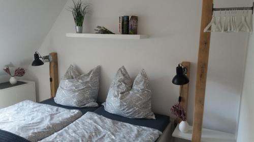a bedroom with two beds with pillows and a shelf at Ferienwohnung Brunnenstrasse in Bremervörde