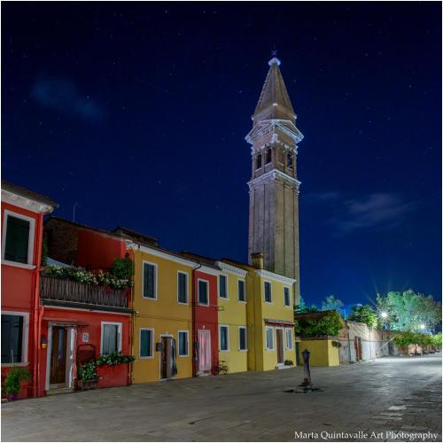 a clock tower in the middle of a street at night at Casa Nova in Burano