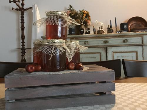 a table with a jar of honey and tomatoes on it at La Corte D'Emilio B&B in Vignola