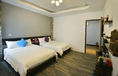 ein Hotelzimmer mit zwei Betten und einem Spiegel in der Unterkunft And B&B in Altstadt von Hengchun