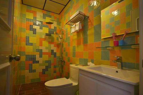 a colorful bathroom with a toilet and a sink at And B&B in Hengchun