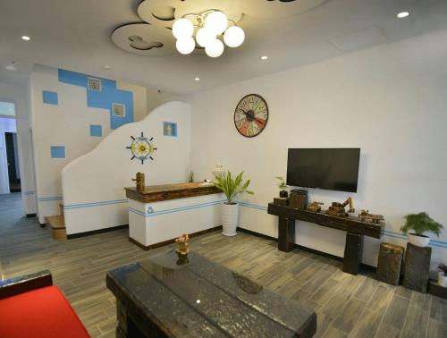 a living room with a flat screen tv on a wall at And B&B in Hengchun