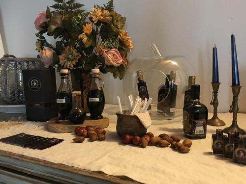 a counter with bottles of wine and a vase of flowers at La Corte D'Emilio B&B in Vignola