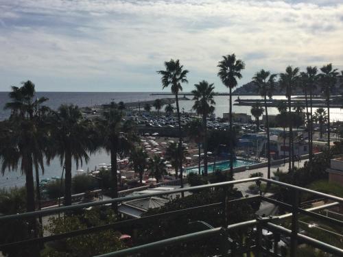 a view of a resort with palm trees and the ocean at B&b note di mare in Imperia