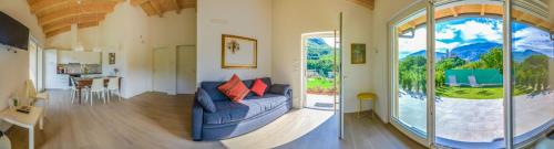 a living room with a couch and a large window at La Gazza Ladra Apartments - Garda Chill Out in Drena