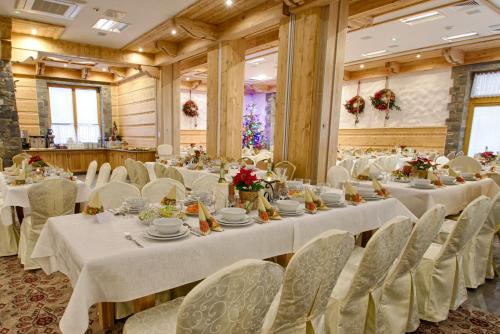 a banquet hall with white tables and chairs at Hotel Toporów in Białka Tatrzanska