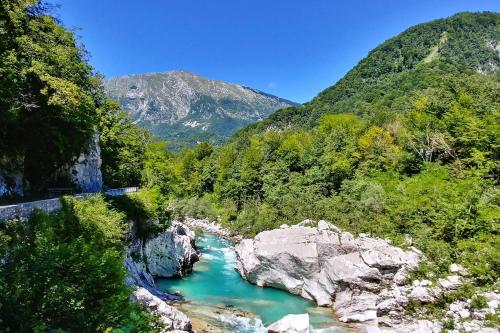 a river in the mountains with a bridge over it at Počitniška hiša Lazar in Kobarid