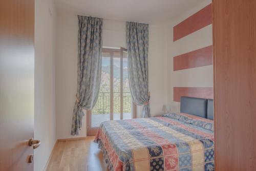 a bedroom with a bed and a window at Villa Due Leoni - Residence in Brenzone sul Garda