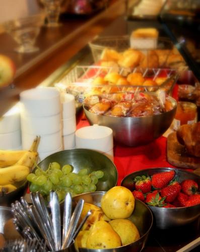un buffet con tazones de fruta en una mesa en Logis Hotel Lons-le-Saunier - Restaurant Le Grill, en Lons-le-Saunier