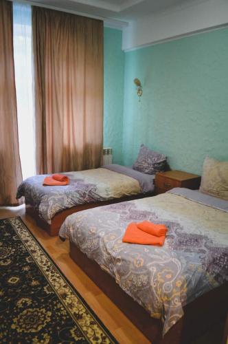 a bedroom with two beds with orange towels on them at Lisova Perlina in Volya Bortatovska