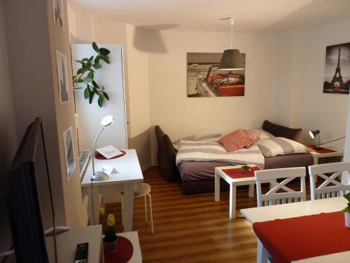 a small living room with a couch and a bed at City Apartment Jena in Jena