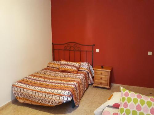 Pensión Restaurante Páramo في لا هيرادورا: غرفة نوم صغيرة مع سرير وموقف ليلي