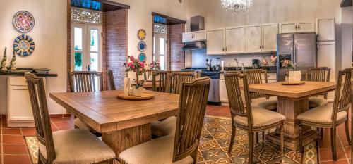 a kitchen with a table, chairs and a refrigerator at Colonial 154 H Boutique in Santo Domingo