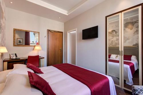 a hotel room with two beds and a tv at Hotel Nazionale in Rome