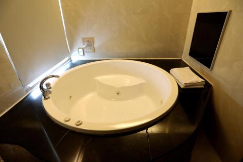a bathroom with a white sink on a black counter at Hua Jia Motel in Tainan