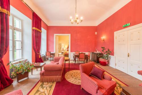 a living room with red walls and chairs and a table at Kernu Manor Hotel & SPA in Kernu