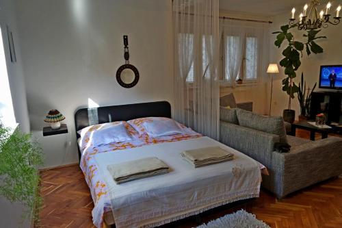 1 dormitorio con 1 cama y 1 sofá en Belvárosi Studio Apartman, en Győr