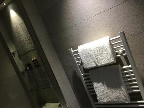 a bathroom with two towels on a rack and a shower at Grey Street Hotel in Newcastle upon Tyne