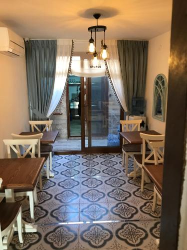 a dining room with tables and chairs and a floor at Ayshe Hotel in Foça