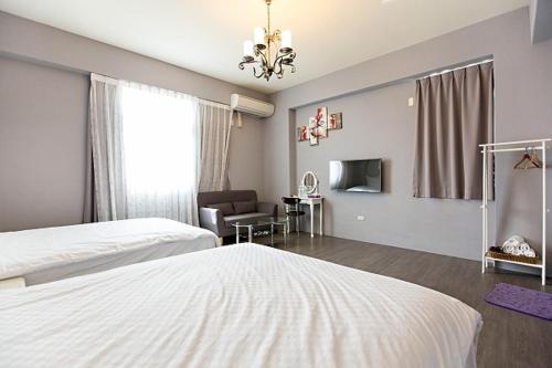 ein Schlafzimmer mit zwei Betten und ein Wohnzimmer in der Unterkunft Slowly B&B in Taitung