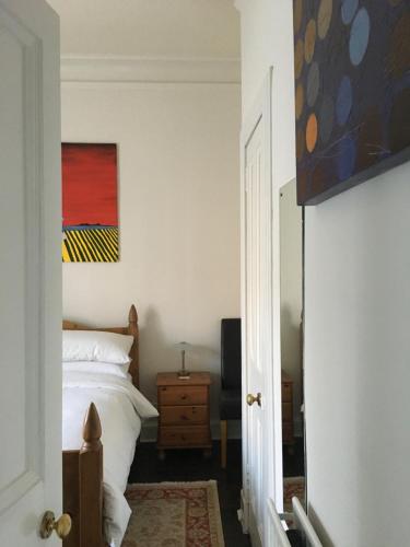 エディンバラにあるGoldenacre Private Room (Homestay)のベッドルーム1室(ベッド1台付)が備わります。壁には絵画が飾られています。