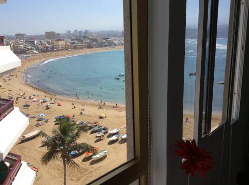 a view of a beach from a hotel window at Apartamento Toñi in Las Palmas de Gran Canaria