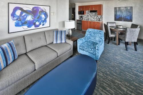 a living room with a couch and a dining room at Chateau Victoria Hotel & Suites in Victoria