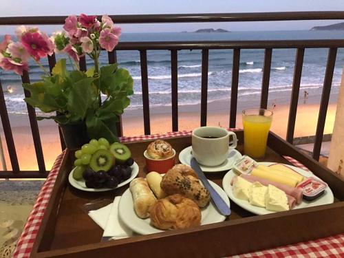 フロリアノポリスにあるPalm Beach Apart Hotelのビーチ沿いのバルコニーに朝食用の食材トレイ